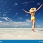 Женщина, стоящая на пляже с поднятыми руками 9