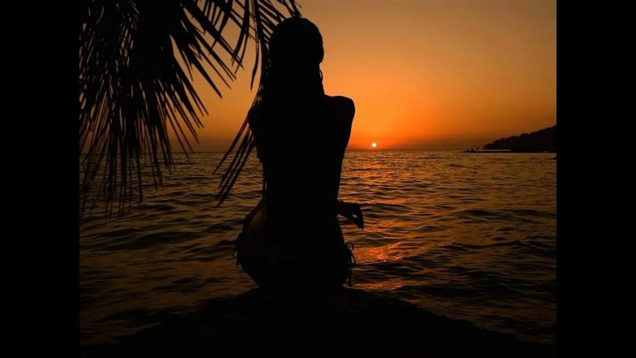 Женщина, стоящая в океане на закате 9
