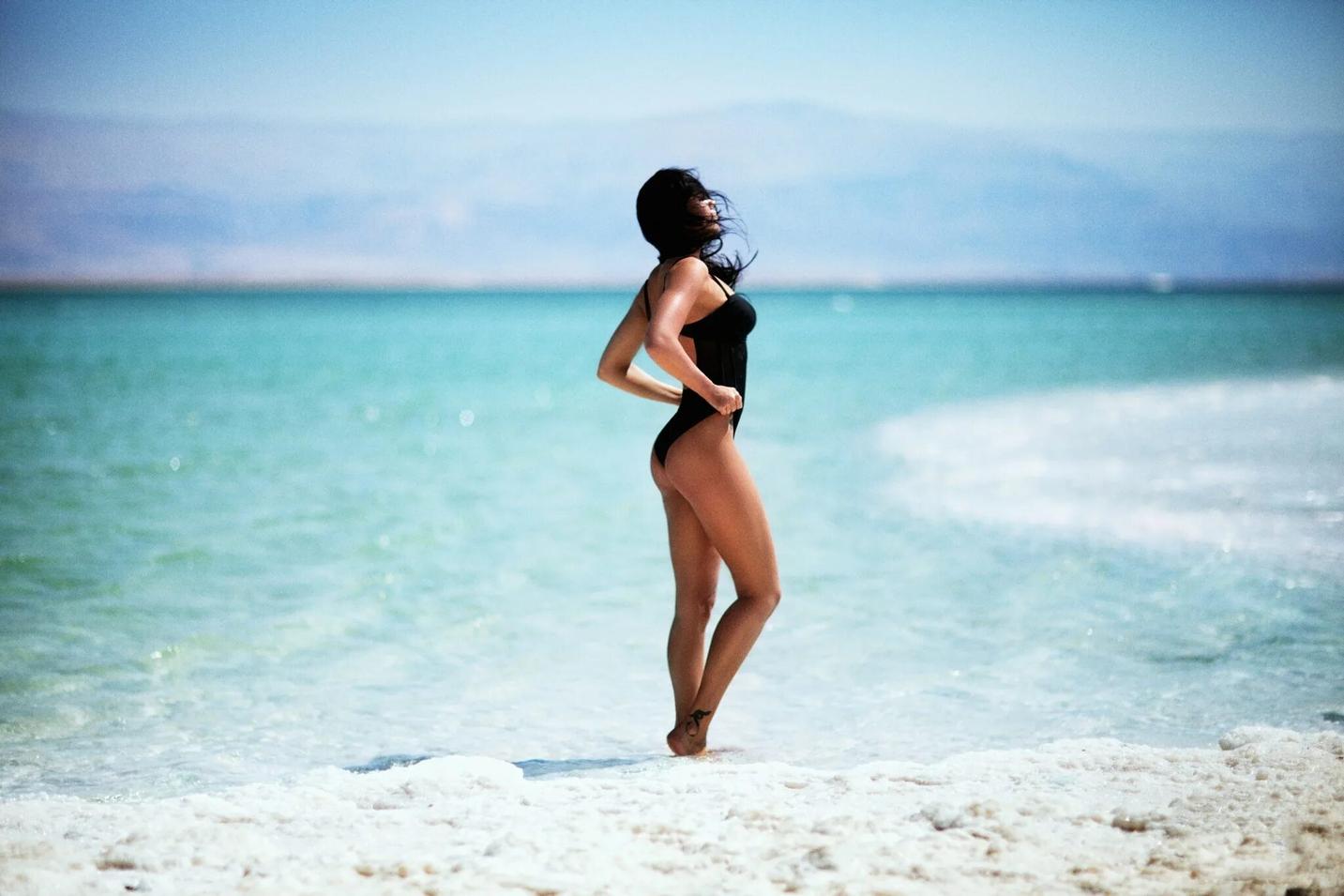 Женщина, стоящая на пляже со скрещенными руками 9