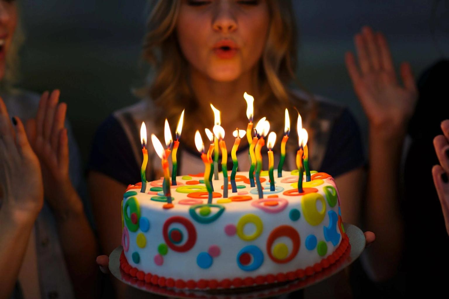 Маленькая девочка держит праздничный торт со свечами 9