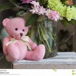Плюшевый мишка сидит в корзине с цветами 9