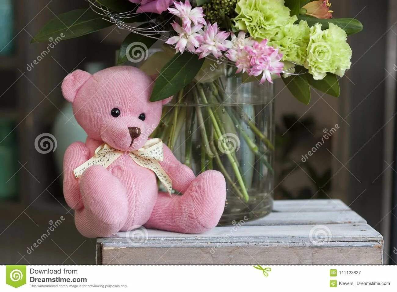 Плюшевый мишка сидит в корзине с цветами 9